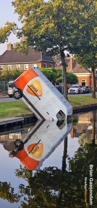 Bezorgbus rolt van oprit in het water